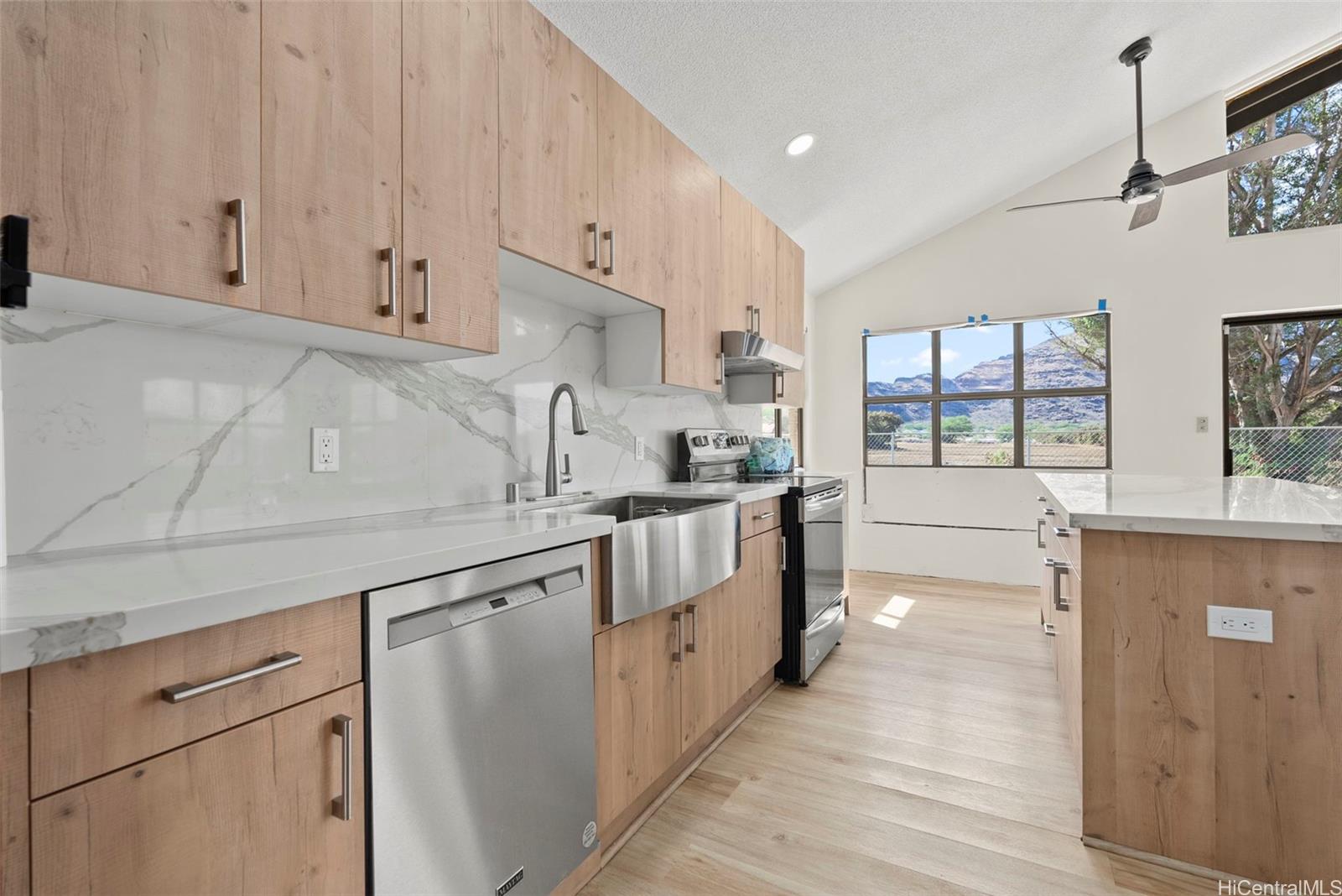 87-1087 Apuupuu Road Waianae, HI 96792 - Photo 7 of 25 a kitchen with granite countertop white cabinets and white appliances