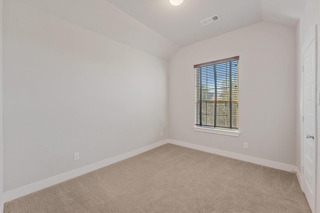 2044 Longbridge Road Forney, TX 75126 - Photo 25 of 40 Carpeted flooring, vaulted ceiling, single window with blinds, recessed lighting, and a paneled door