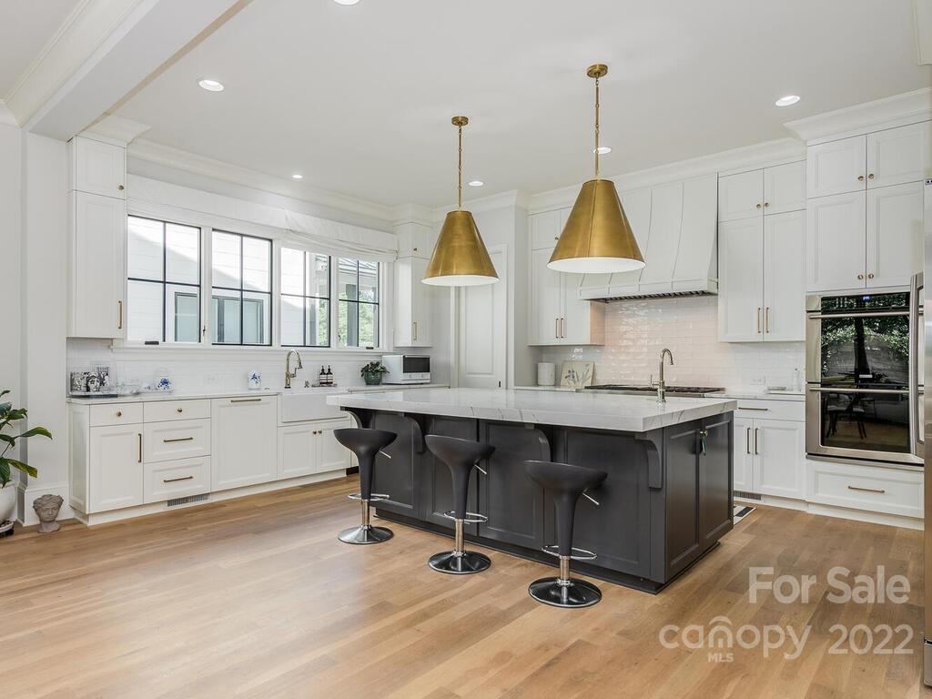 3013 Manor Road Charlotte, NC 28209 - Photo 15 of 41 a kitchen with kitchen island granite countertop a stove a sink and a wooden floors