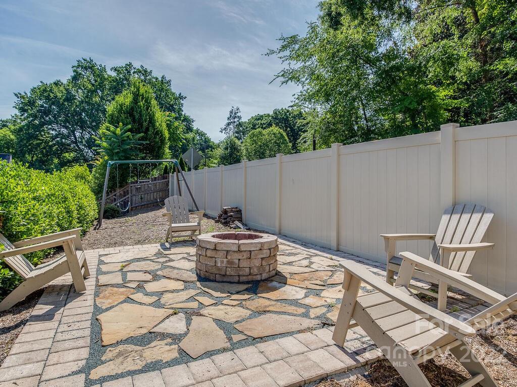 3013 Manor Road Charlotte, NC 28209 - Photo 39 of 41 a backyard of a house with table and chairs potted plants and barbeque
