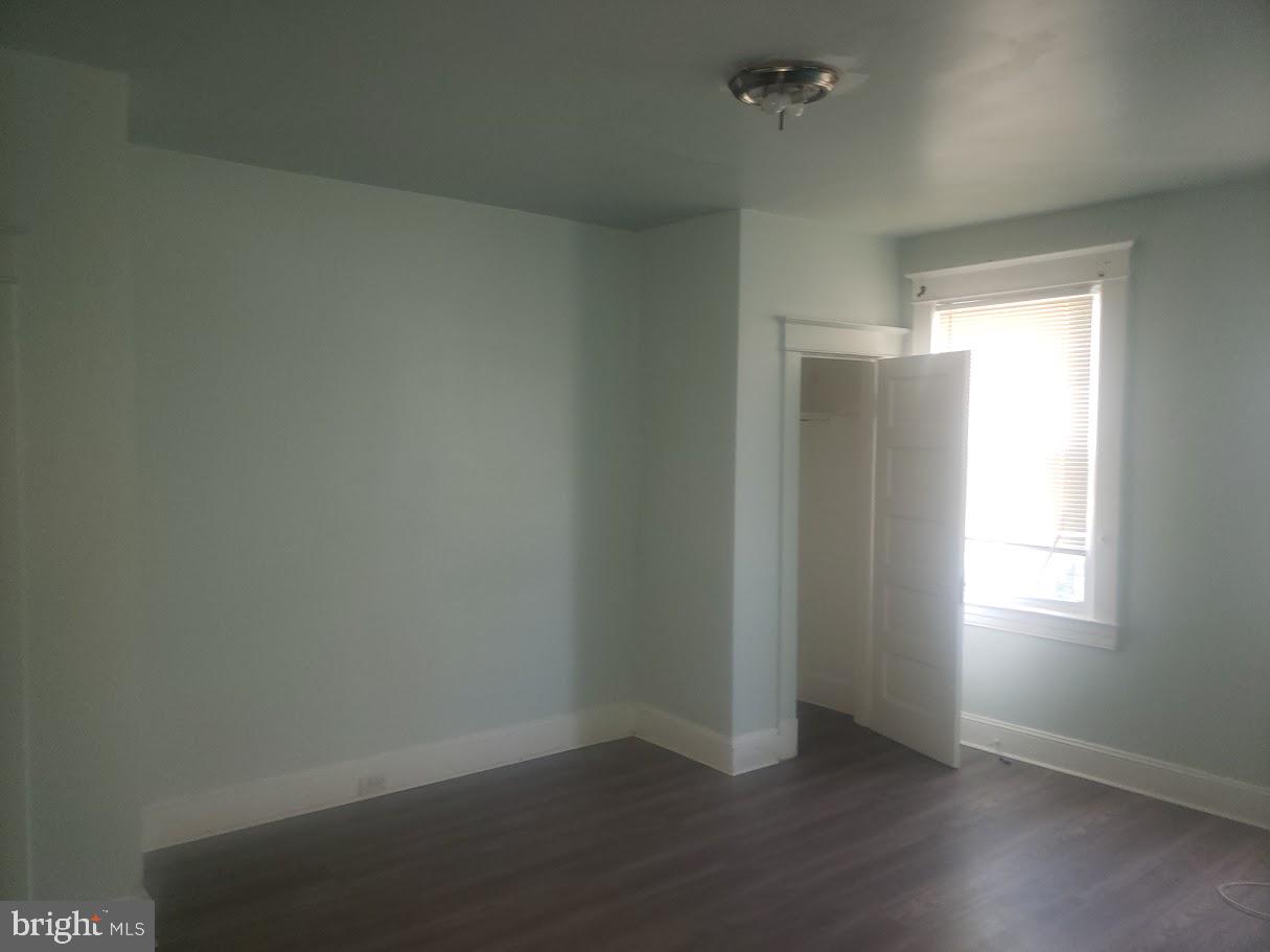 3615 Springdale Avenue Baltimore, MD 21216 - Photo 6 of 17 an empty room with wooden floor and windows