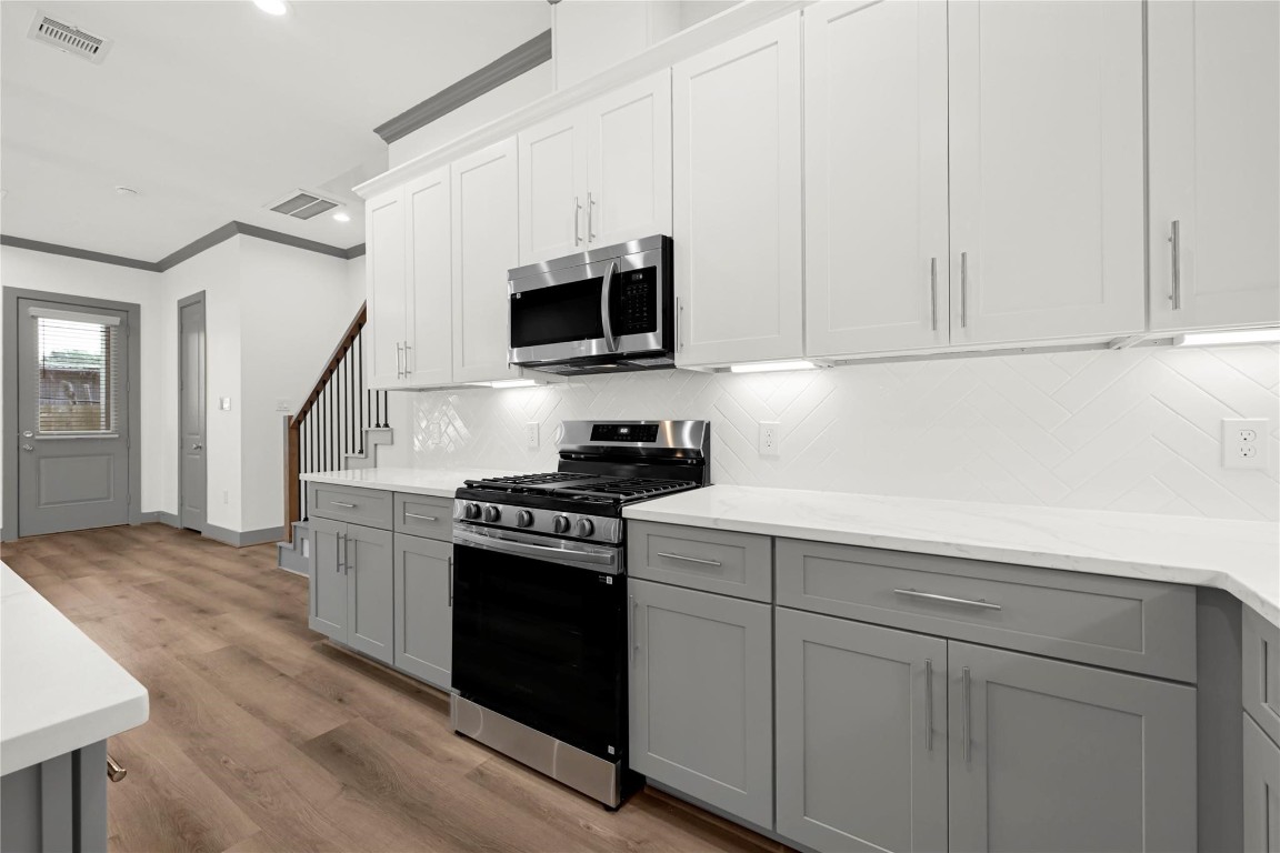 4019 Stassen Street, Unit A Houston, TX 77051 - Photo 16 of 35 a kitchen with white cabinets and black appliances