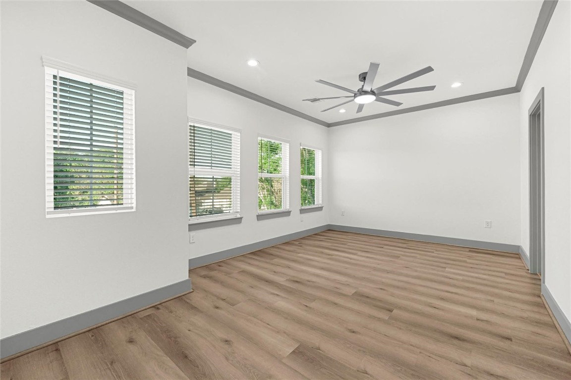 4019 Stassen Street, Unit A Houston, TX 77051 - Photo 21 of 35 an empty room with wooden floor ceiling fan and windows