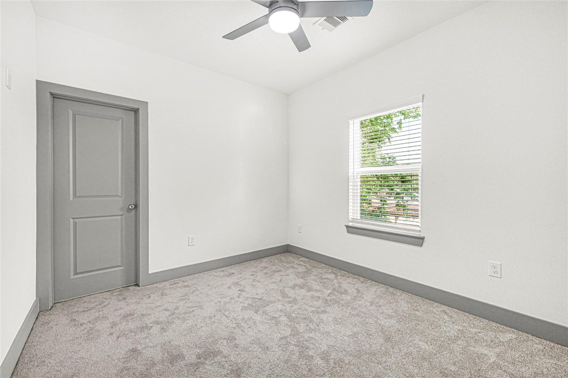 4019 Stassen Street, Unit A Houston, TX 77051 - Photo 31 of 35 an empty room with a chandelier fan and windows