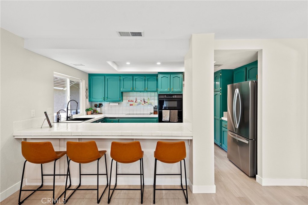 5649 Roane Drive Oceanside, CA 92057 - Photo 11 of 42 a kitchen with stainless steel appliances a table and chairs in it