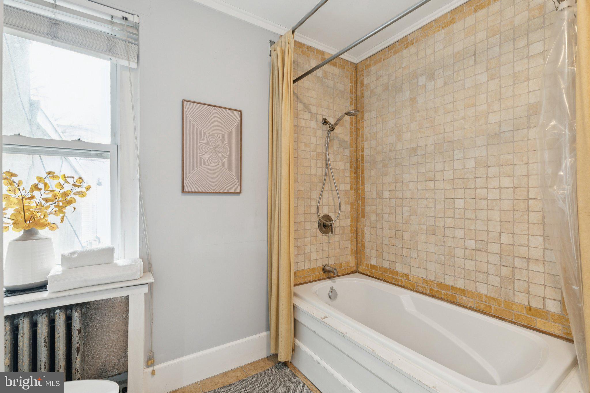 1228 Catharine Street Philadelphia, PA 19147 - Photo 27 of 48 a bathroom with a tub a sink and a window