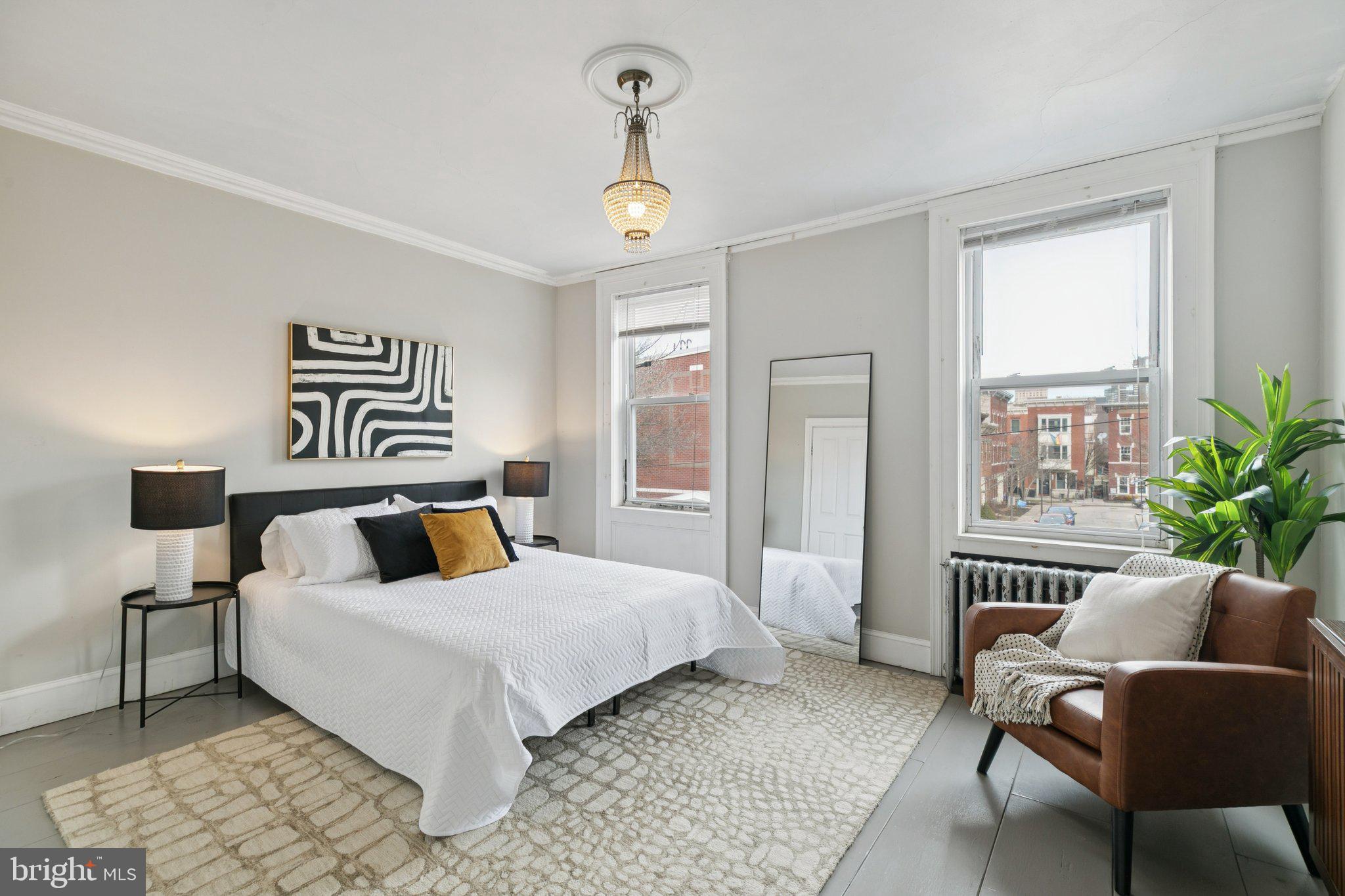 1228 Catharine Street Philadelphia, PA 19147 - Photo 28 of 48 a bedroom with a large bed and a chandelier