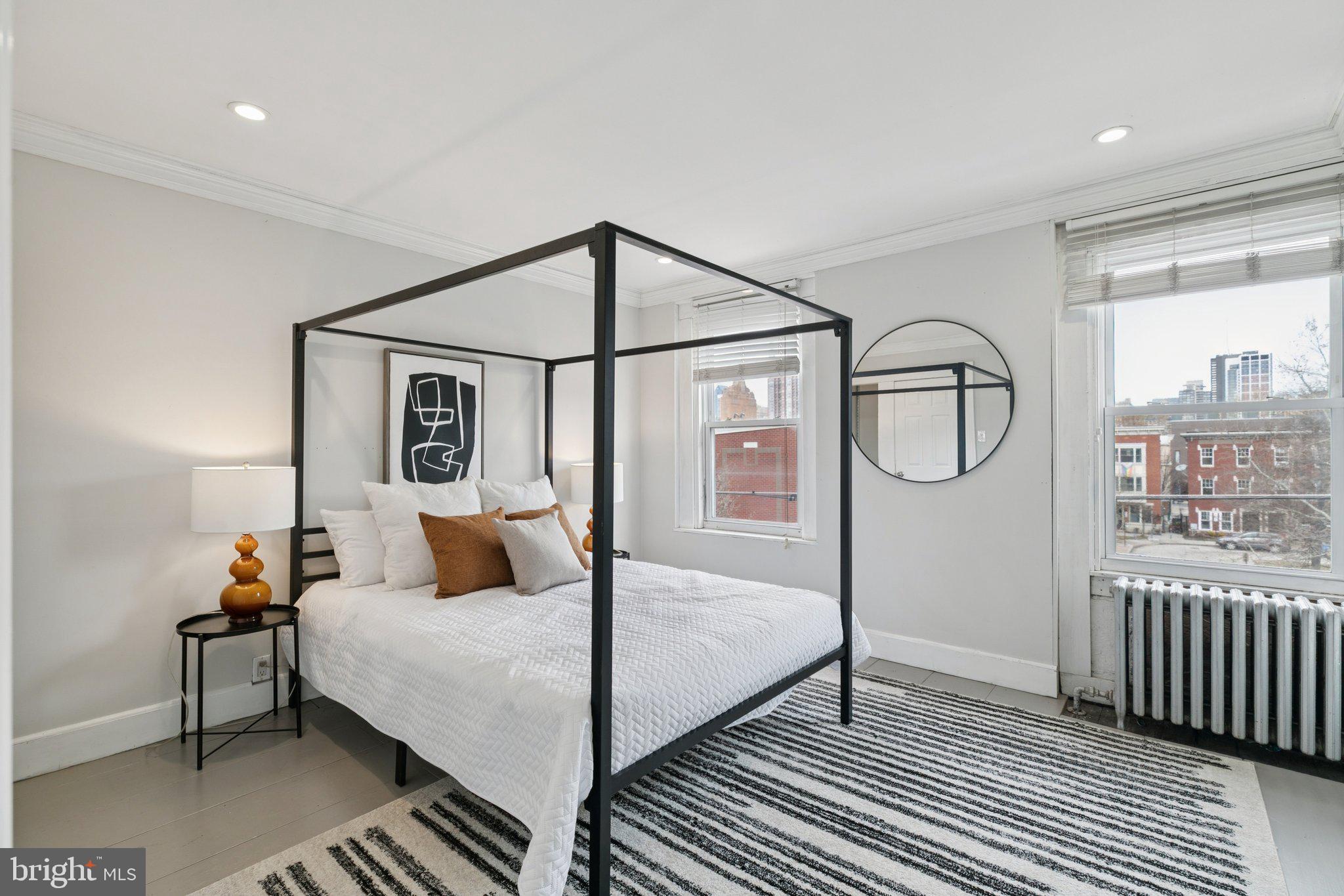 1228 Catharine Street Philadelphia, PA 19147 - Photo 36 of 48 a bedroom with a bed a mirror and windows