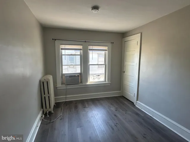 an empty room with windows and wooden floor