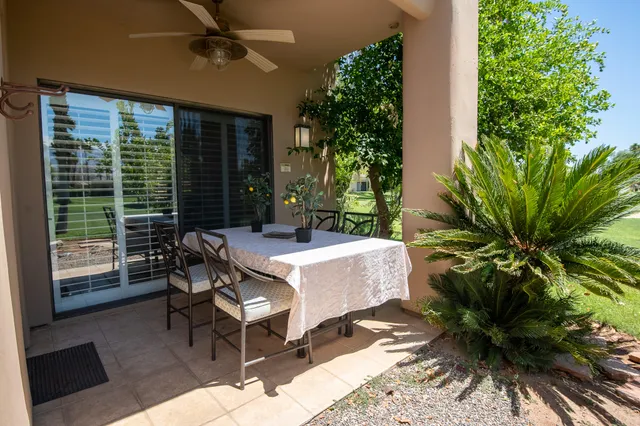 a view of a patio with a table and chairs and potted plants
