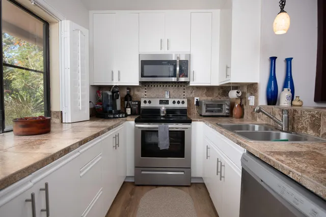 a kitchen with stainless steel appliances granite countertop a sink and a stove