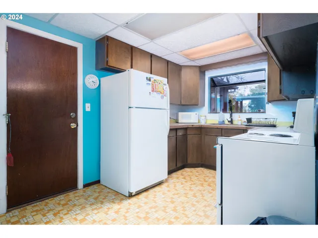 a kitchen with refrigerator and cabinets