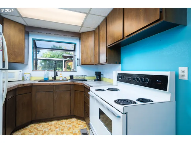 a kitchen with a cabinets and white appliances