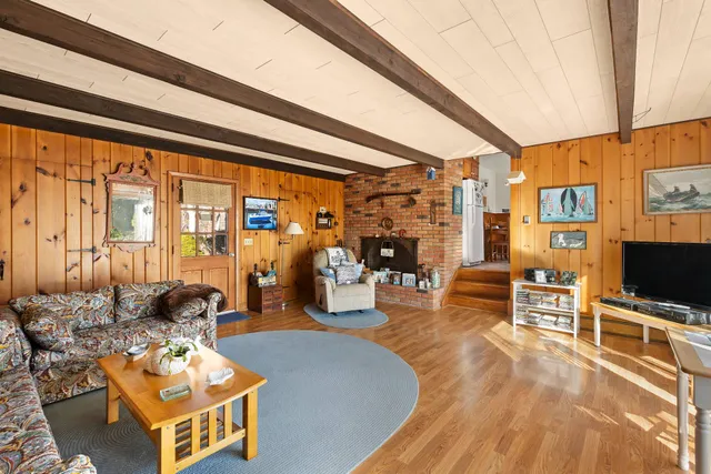 a living room with furniture a flat screen tv and a floor to ceiling window