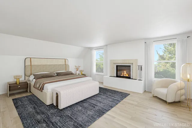 a bedroom with a large bed and a fireplace