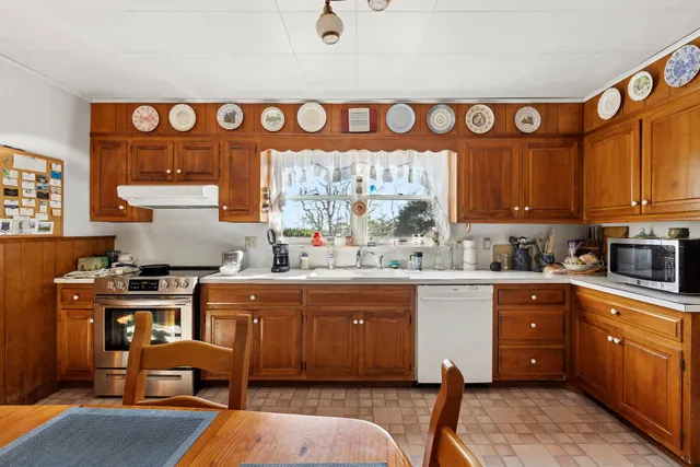 a kitchen with granite countertop a sink a counter space stainless steel appliances and cabinets