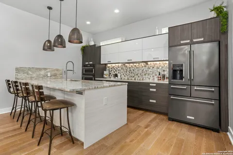 a kitchen with stainless steel appliances granite countertop a sink a stove and a refrigerator