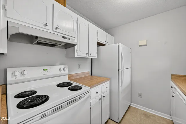a kitchen with a refrigerator and white stove