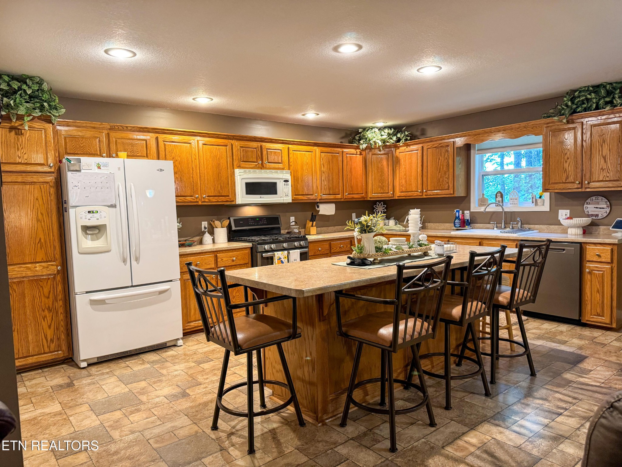 160 Brady Lane Oneida, TN 37841 - Photo 25 of 43 a kitchen with stainless steel appliances a table chairs refrigerator and a window