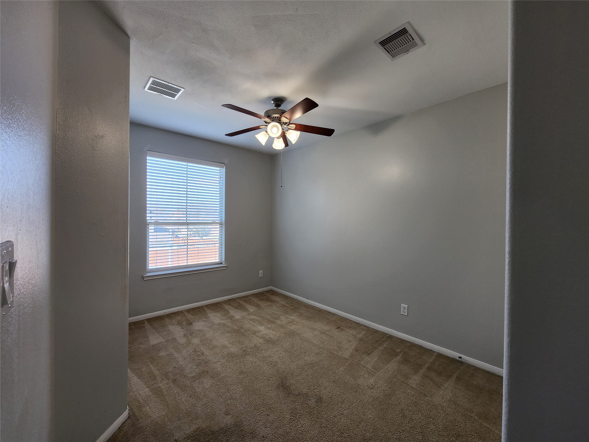 9346 Valley Tree Lane Houston, TX 77089 - Photo 18 of 21 an empty room with windows and chandelier fan