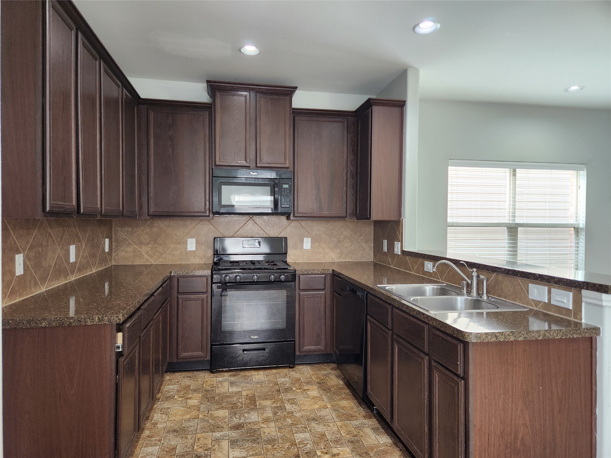 9346 Valley Tree Lane Houston, TX 77089 - Photo 4 of 21 a kitchen with granite countertop a sink stove and cabinets