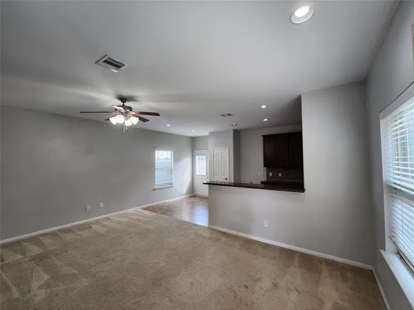 an empty room with windows and fireplace