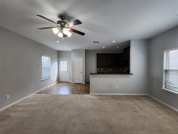 a view of a livingroom with a ceiling fan and window