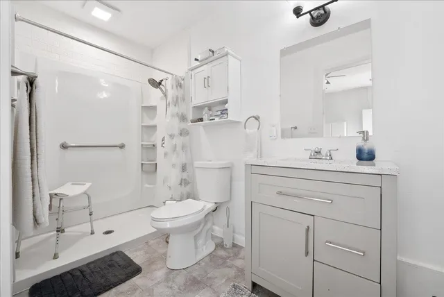 a bathroom with a sink toilet vanity and shower