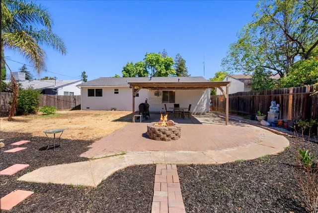 a view of a house with backyard and sitting area