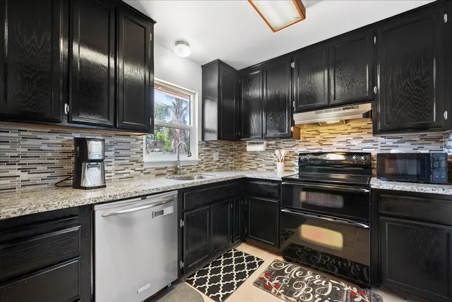 a kitchen with granite countertop stainless steel appliances and wooden cabinets