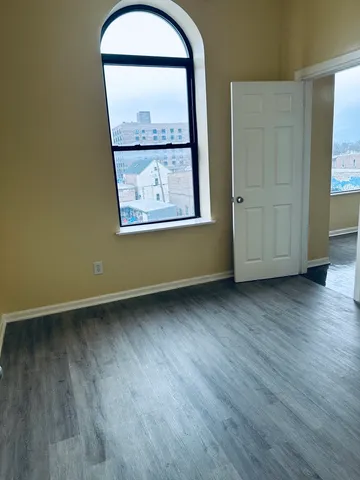 an empty room with wooden floor and a window