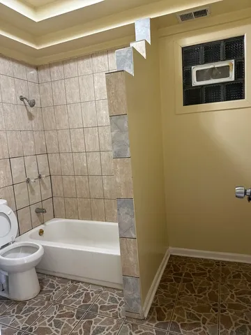 a bathroom with a toilet and a shower