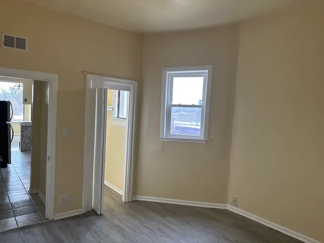 an empty room with wooden floor and closet