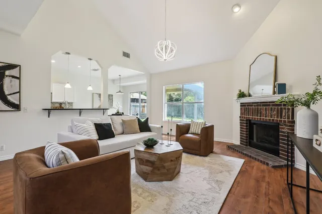 a living room with furniture a fireplace and a large window