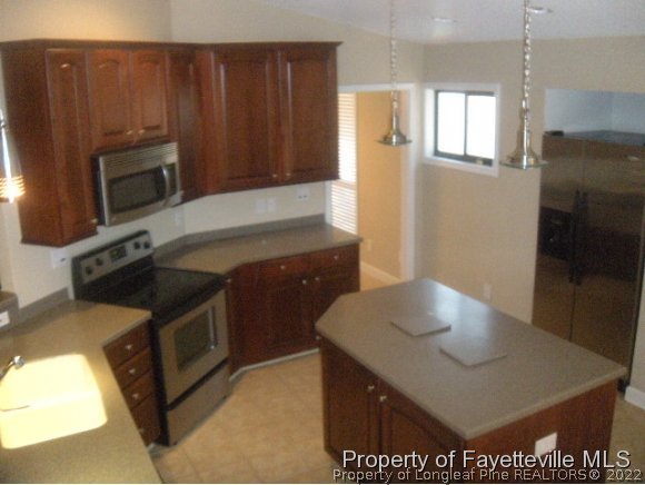 2965 Middlesex Road Fayetteville, NC 28306 - Photo 4 of 25 a kitchen with wooden cabinets and a sink