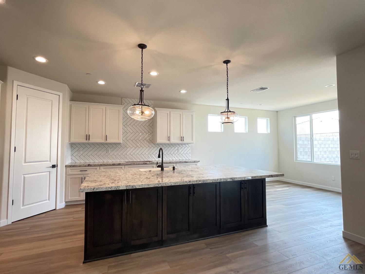 Undisclosed Address Bakersfield, CA 93314 - Photo 2 of 19 Gorgeous exotic granite, designer backsplash, Bronze finishes, under cabinet storage on island, pendant lighting, trash drawer/recycle bin, soft close plus more.