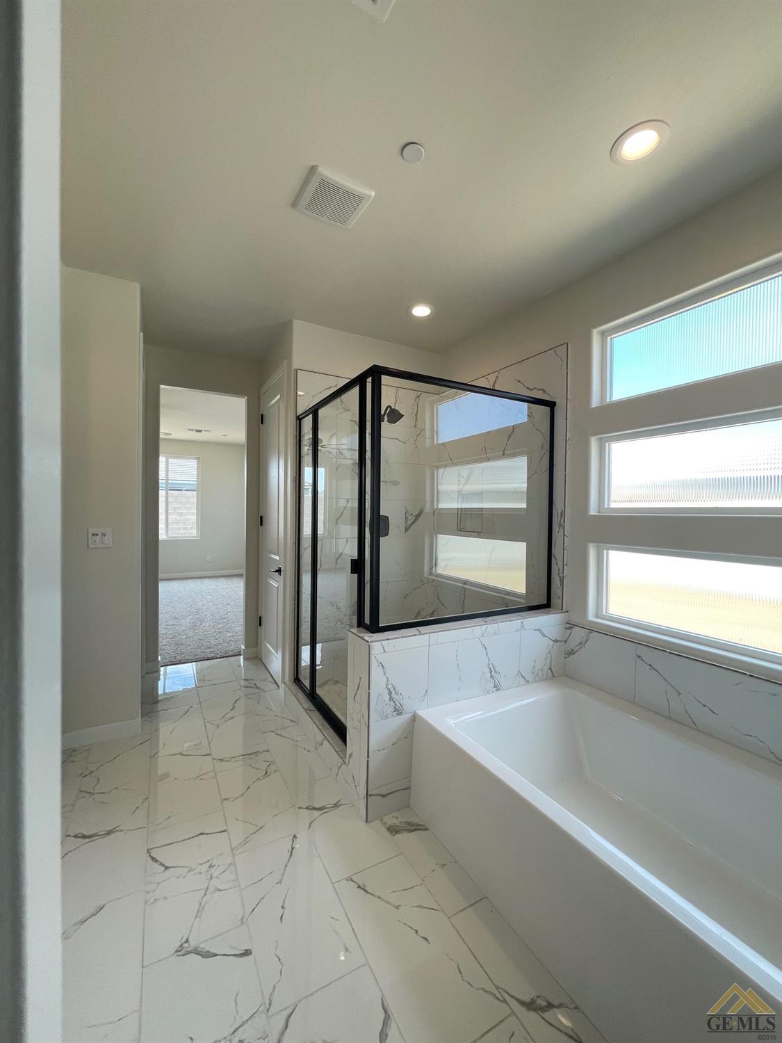 Undisclosed Address Bakersfield, CA 93314 - Photo 7 of 19 Master ensuite features gorgeous marble look tile, tub and shower.
