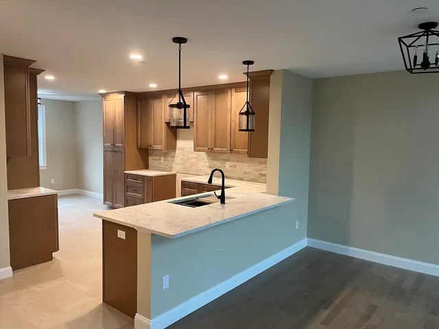 a kitchen with kitchen island white cabinets and refrigerator