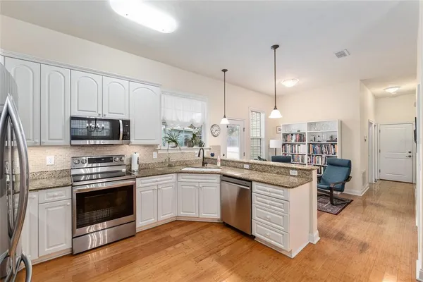 a kitchen with a sink stove and oven