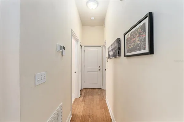a view of a hallway with wooden floor and closet