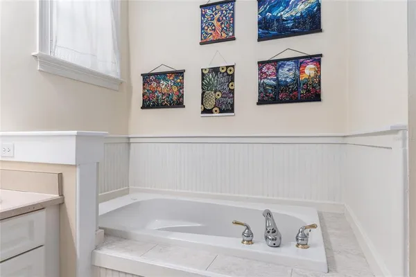a bathroom with a bathtub and a picture on the wall