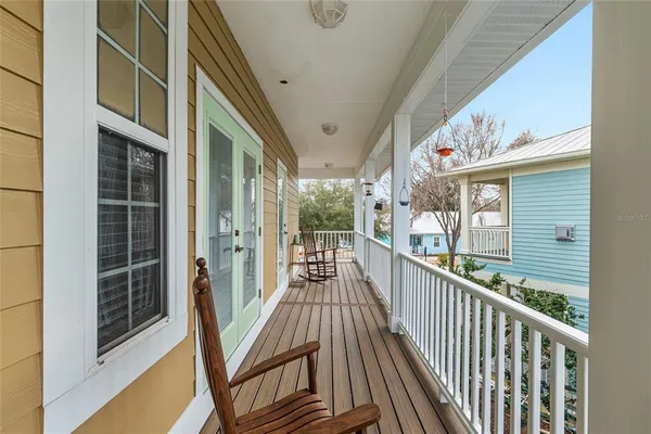 a view of a porch with wooden floor and furniture