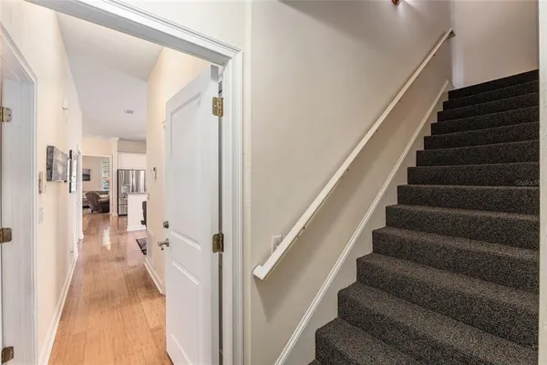 a view of a hallway with wooden floor and staircase