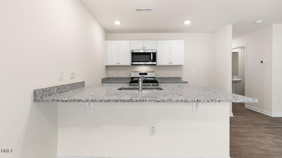 17 Bee Garden Angier, NC 27501 - Photo 6 of 33 a kitchen with granite countertop a sink and a stove top oven