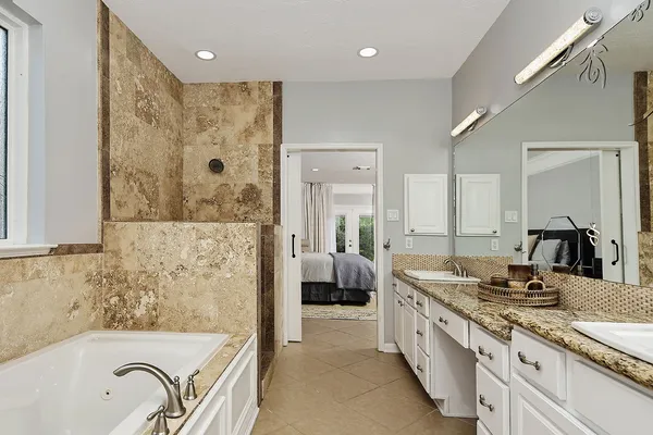 a bathroom with a tub sink and mirror