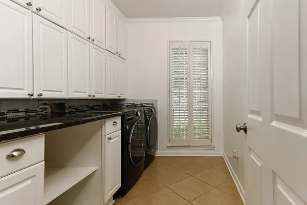 a utility room with stainless steel appliances a stove a sink and a refrigerator