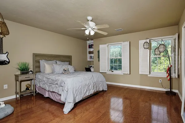 a bedroom with a large bed chandelier and a large window