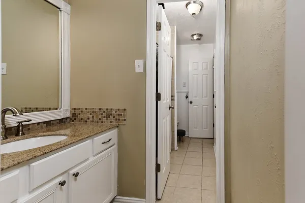a bathroom with a granite countertop sink a mirror and a