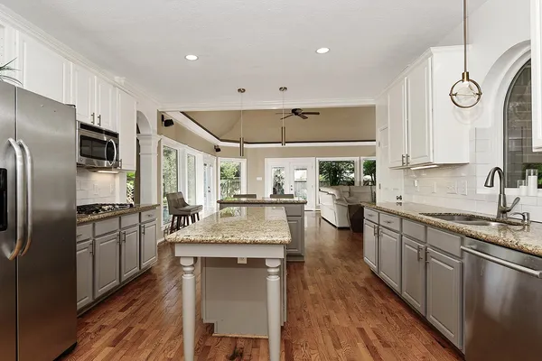 a kitchen with stainless steel appliances granite countertop a sink stove and refrigerator