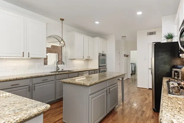 a kitchen with stainless steel appliances granite countertop a sink stove and refrigerator